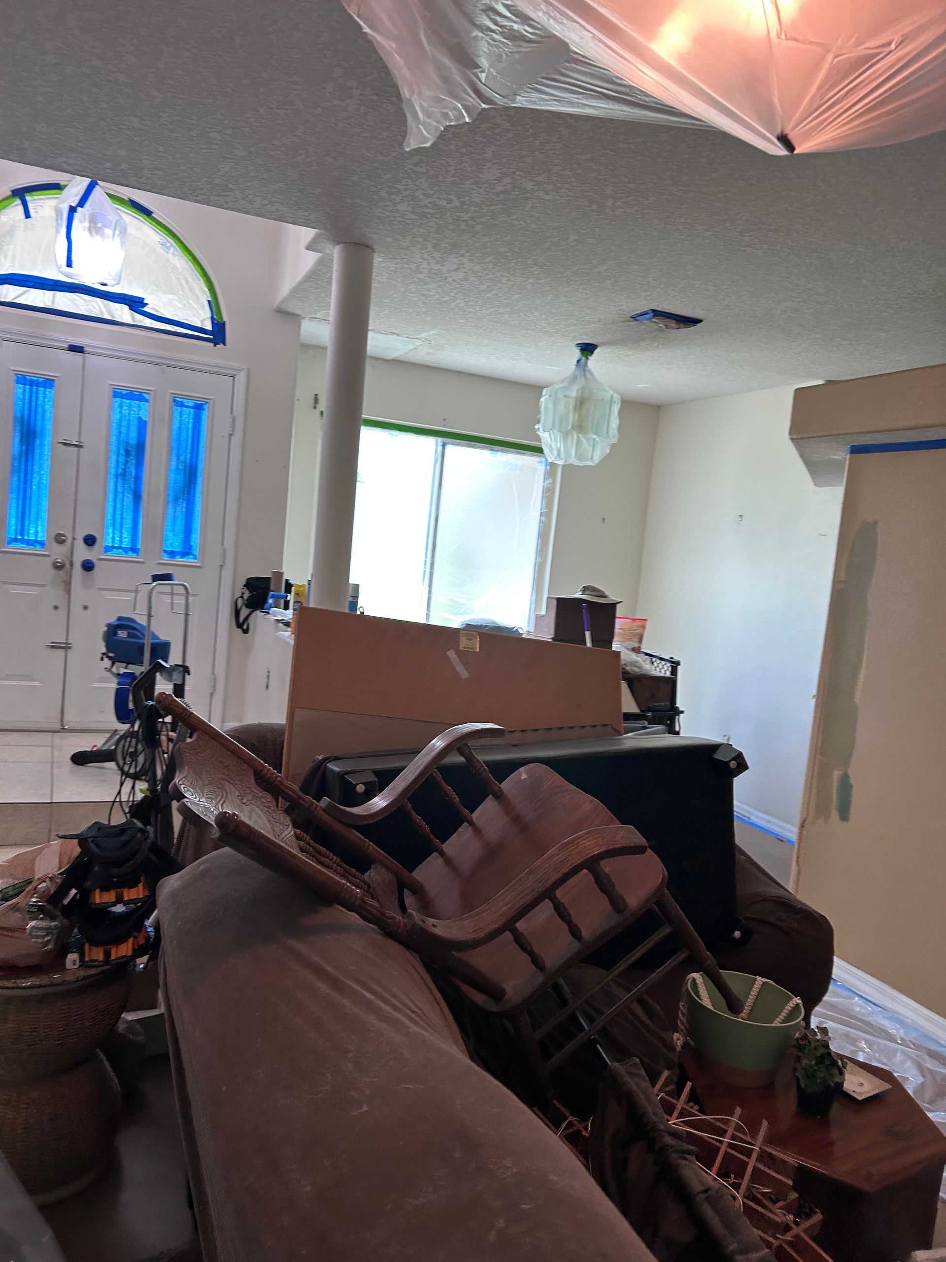 A living room with a couch and chairs stacked on top of each other