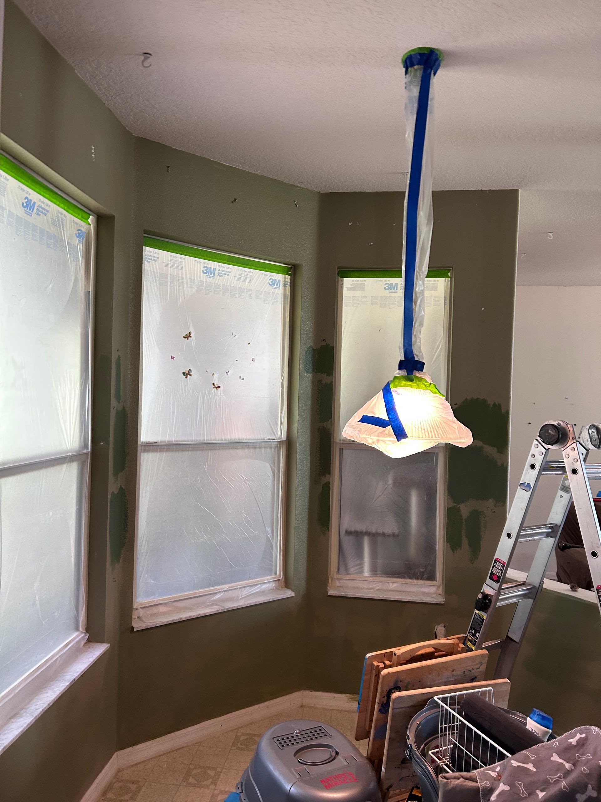 A room is being painted with a light hanging from the ceiling.