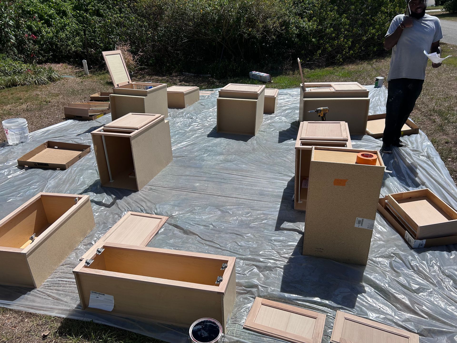 A man is standing next to a bunch of cardboard boxes