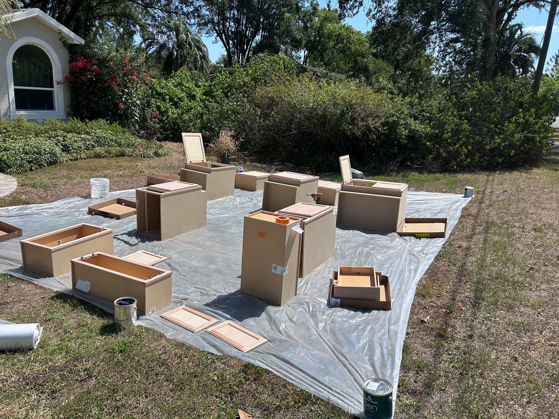 A bunch of boxes are sitting on top of a tarp in a yard.