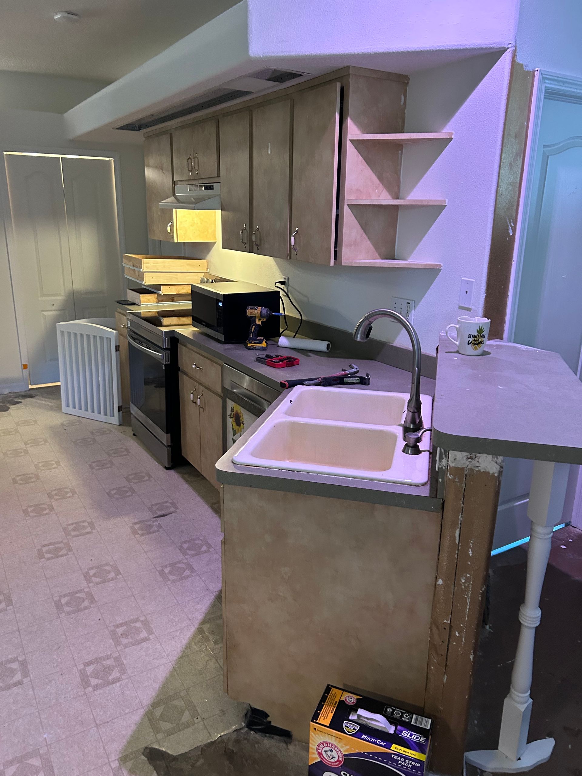 A kitchen with a sink , stove , and microwave.