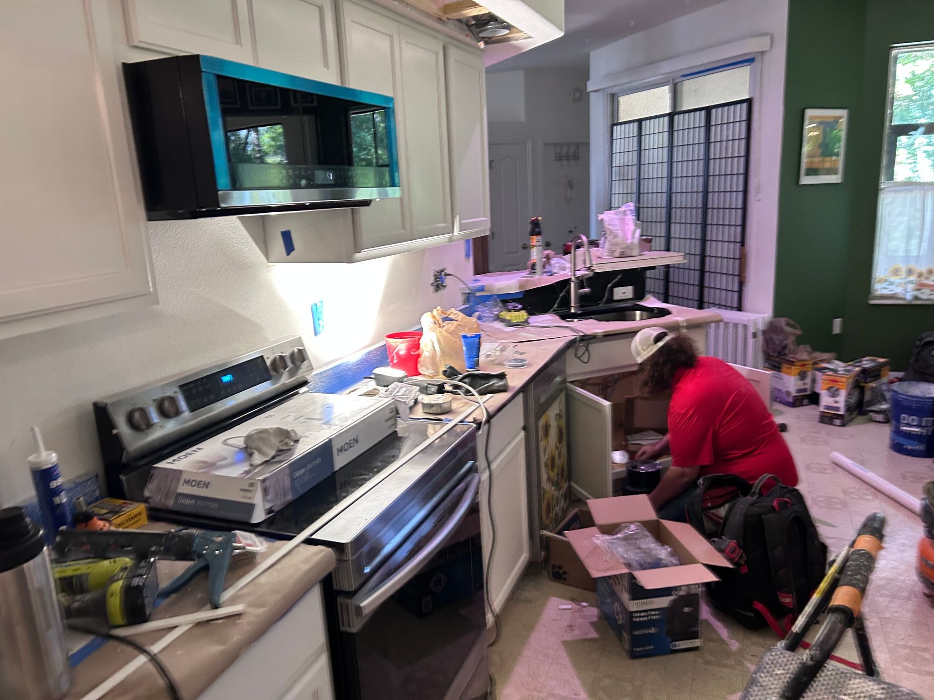 A man in a red shirt is working in a kitchen.