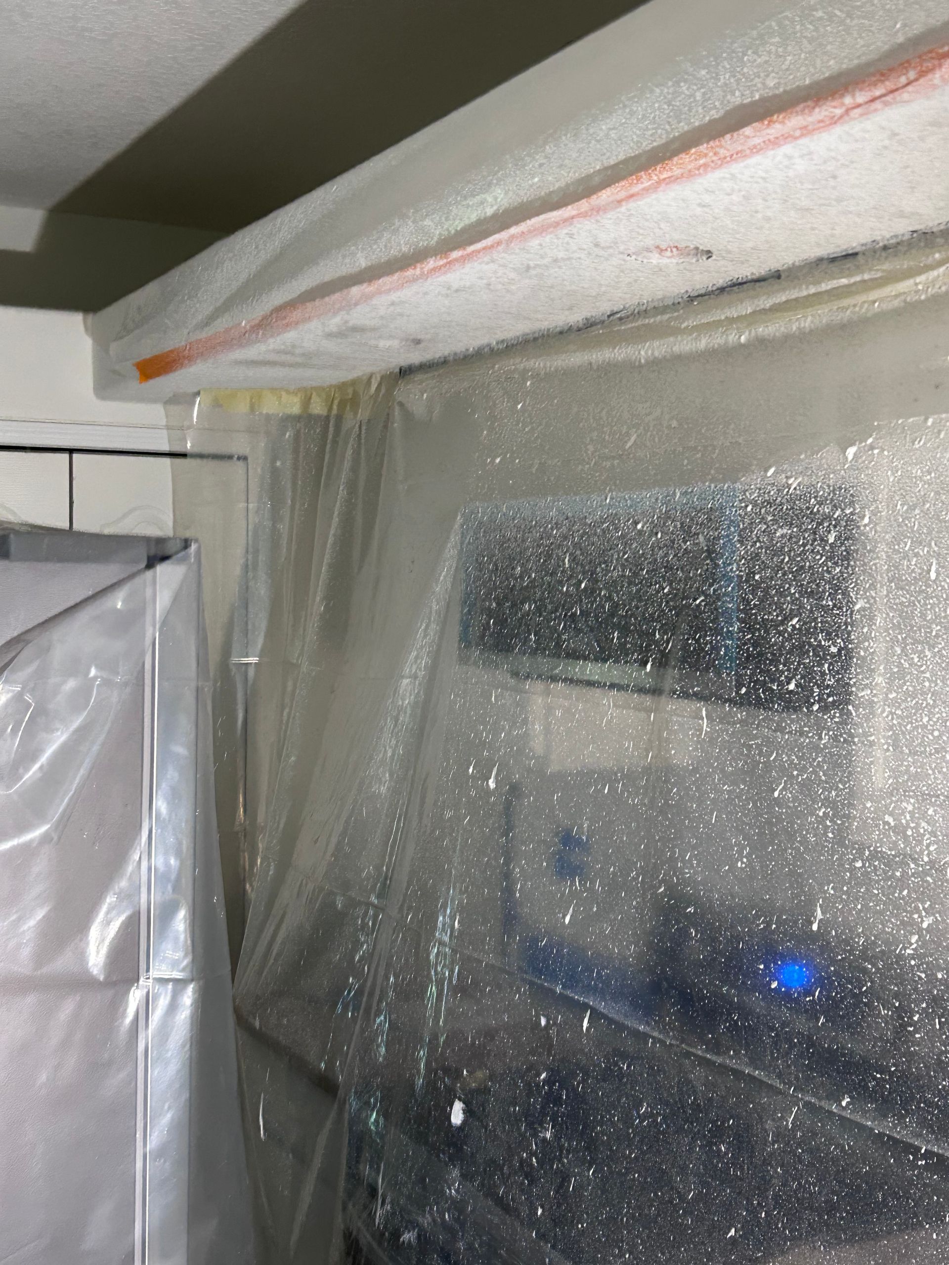 A plastic cover is covering a window in a room