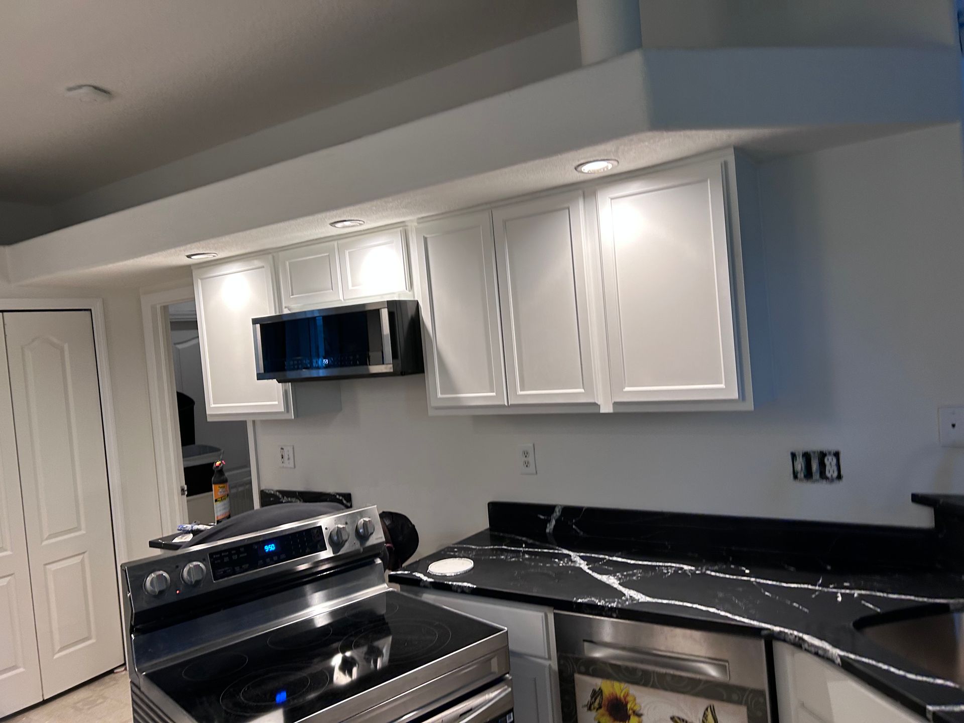 A kitchen with stainless steel appliances and white cabinets.