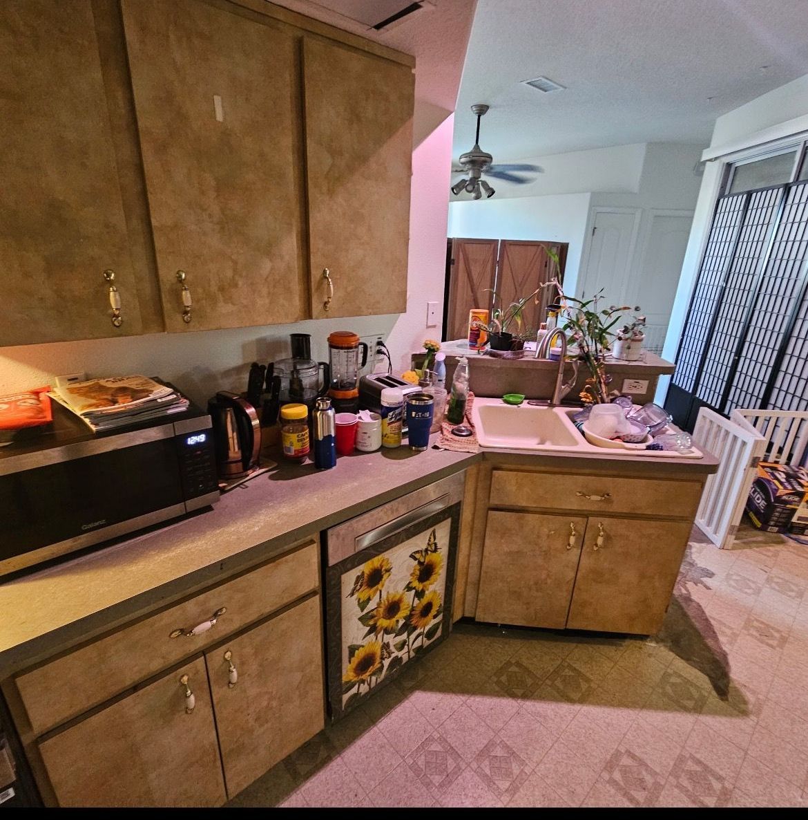 A kitchen with a sink , microwave , and cabinets