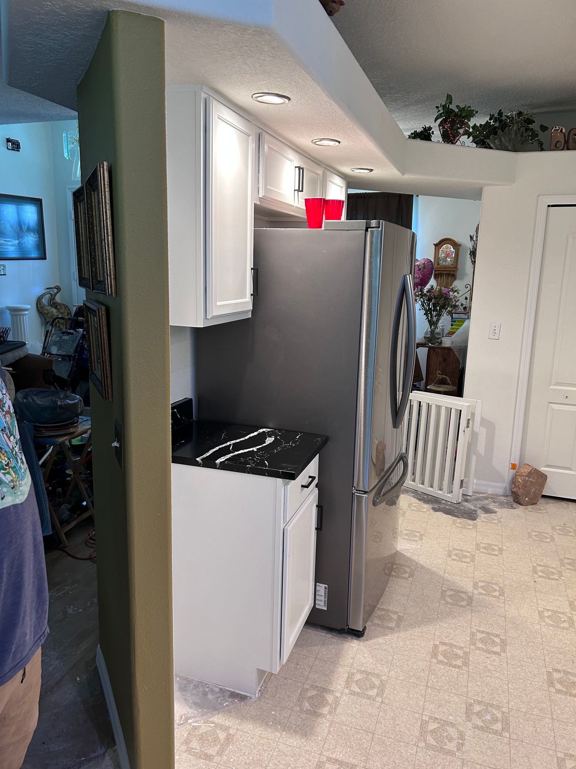 A kitchen with a refrigerator , sink , and cabinets.