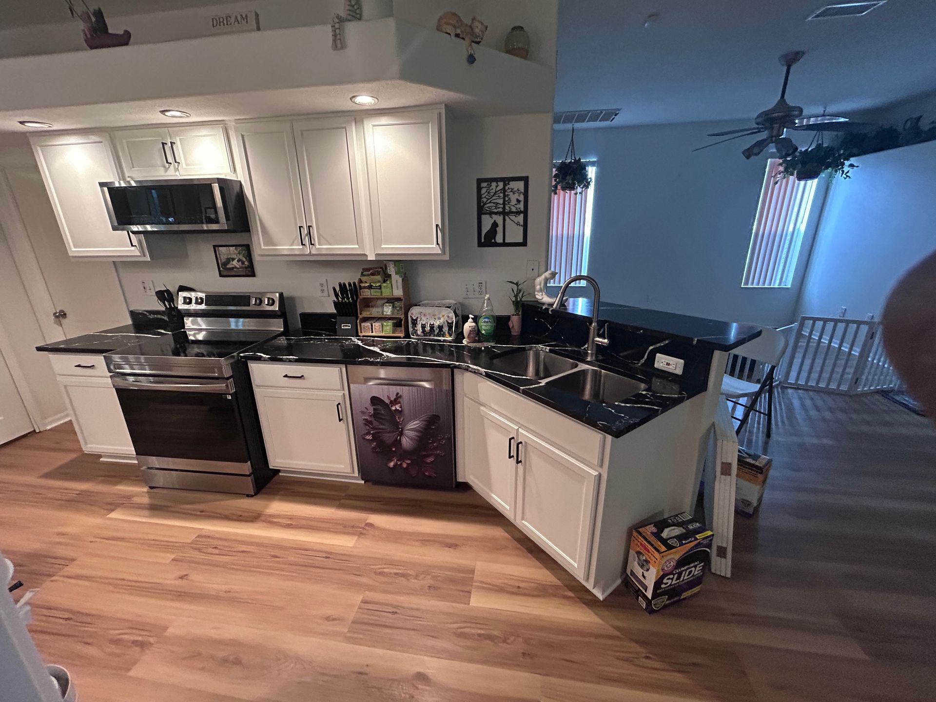 A kitchen with white cabinets and black counter tops