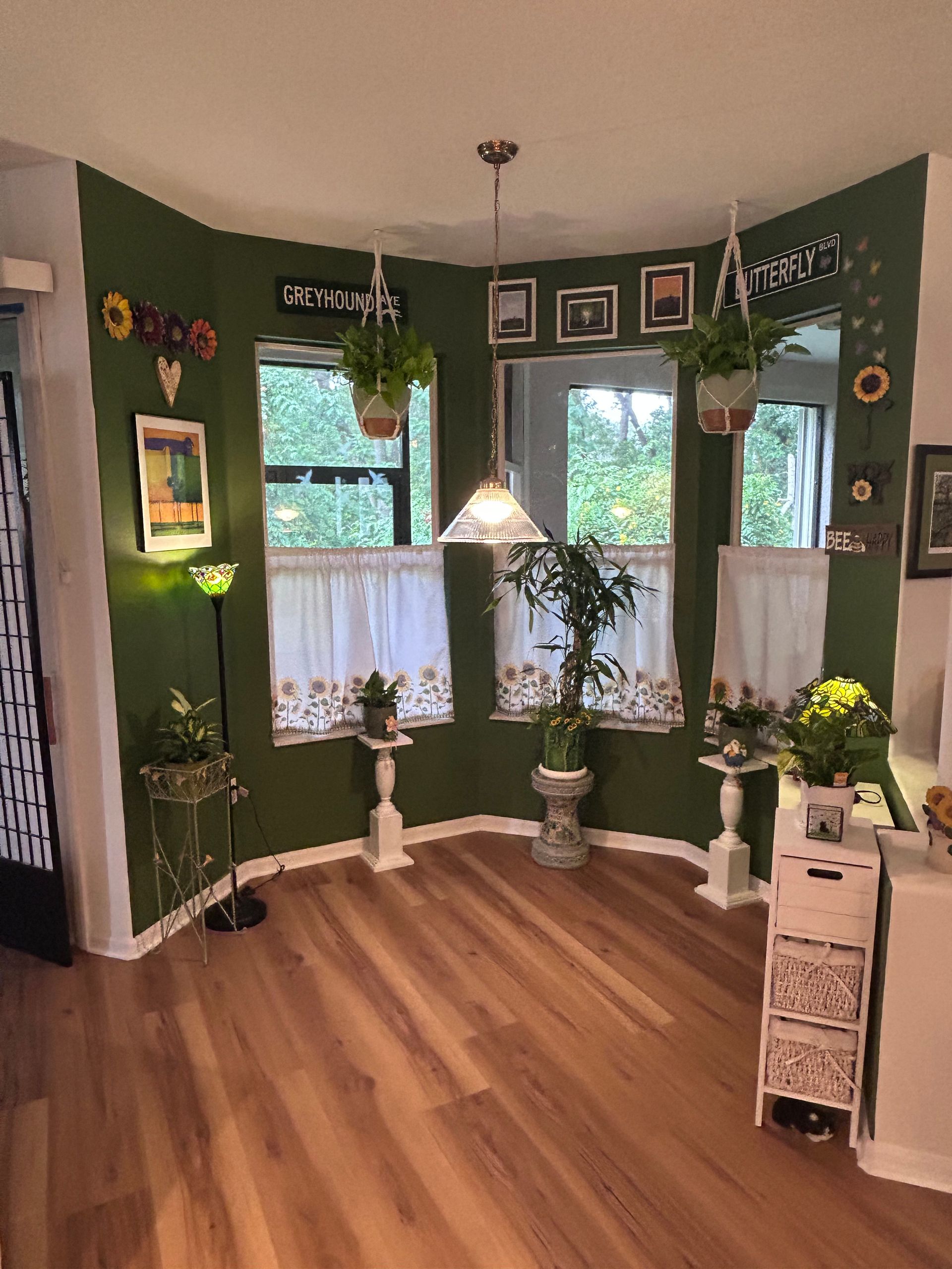 A living room with green walls and a wooden floor.