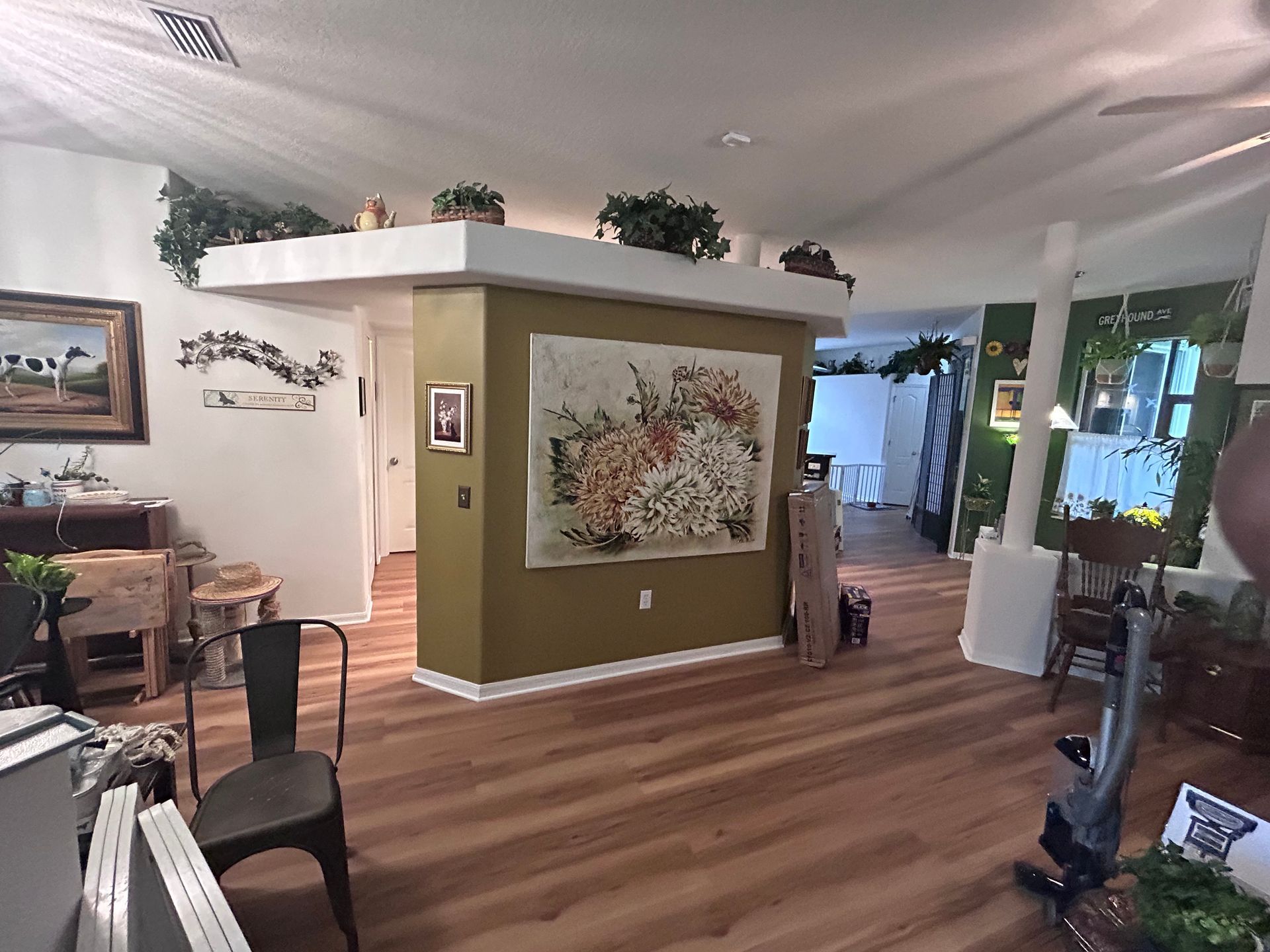 A living room with hardwood floors and a large painting on the wall.