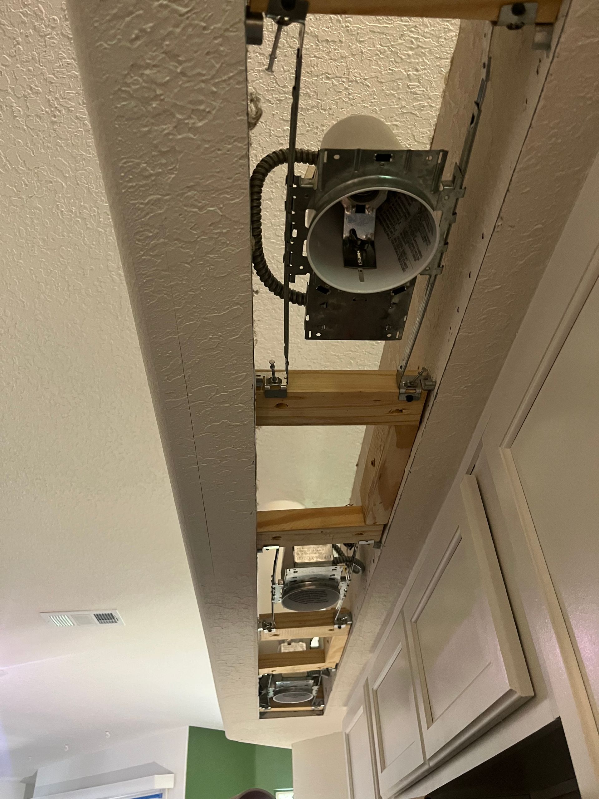 A ceiling fan is being installed in a kitchen.