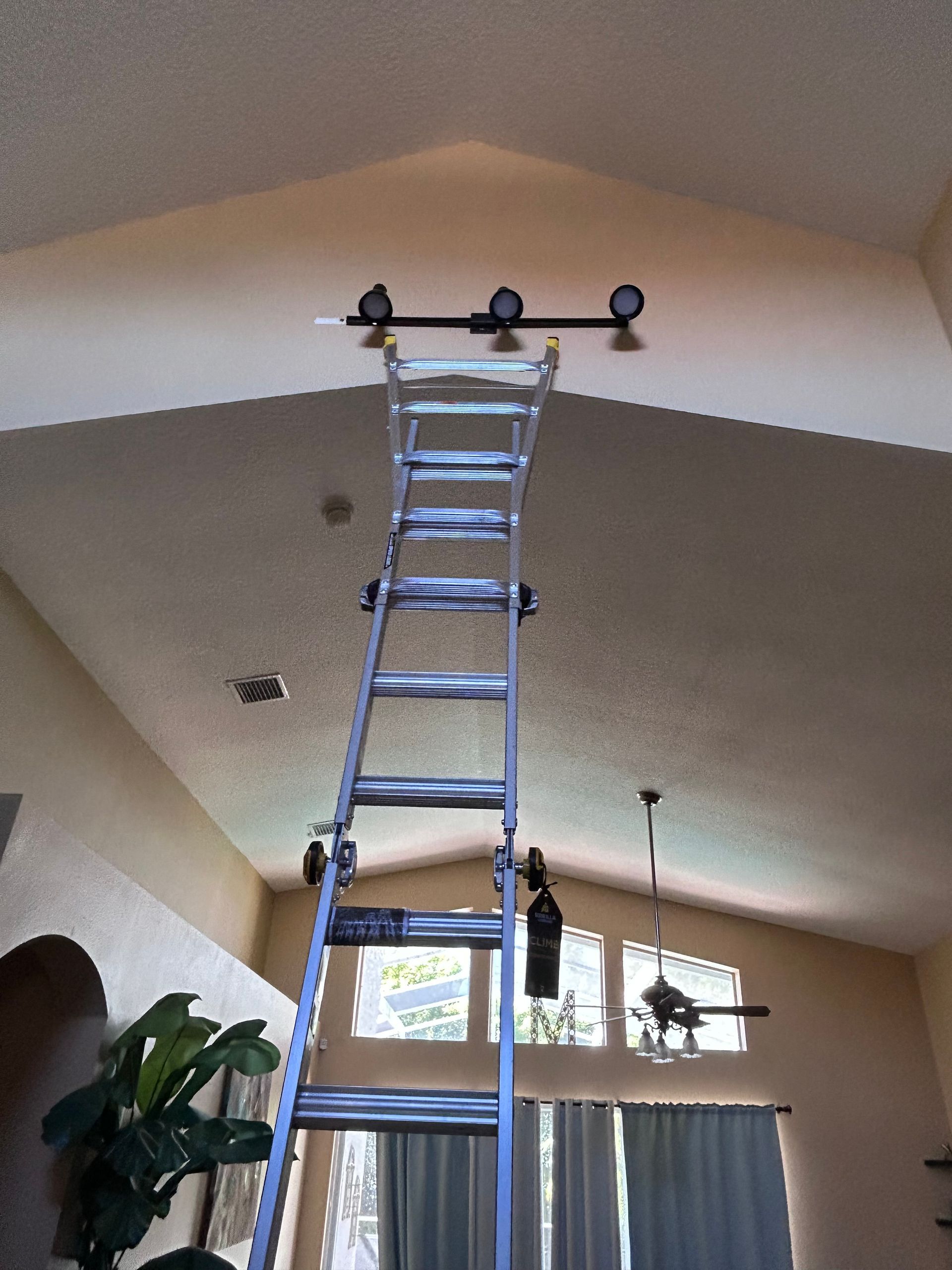 Ladder extending to ceiling with spotlights. Interior view of a home.