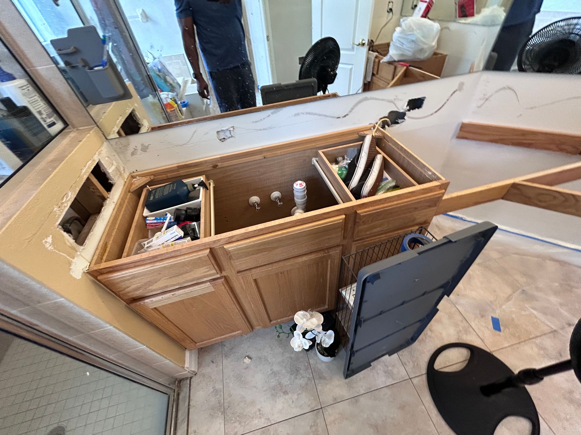 Bathroom vanity cabinet with open drawers, partially dismantled during renovation.