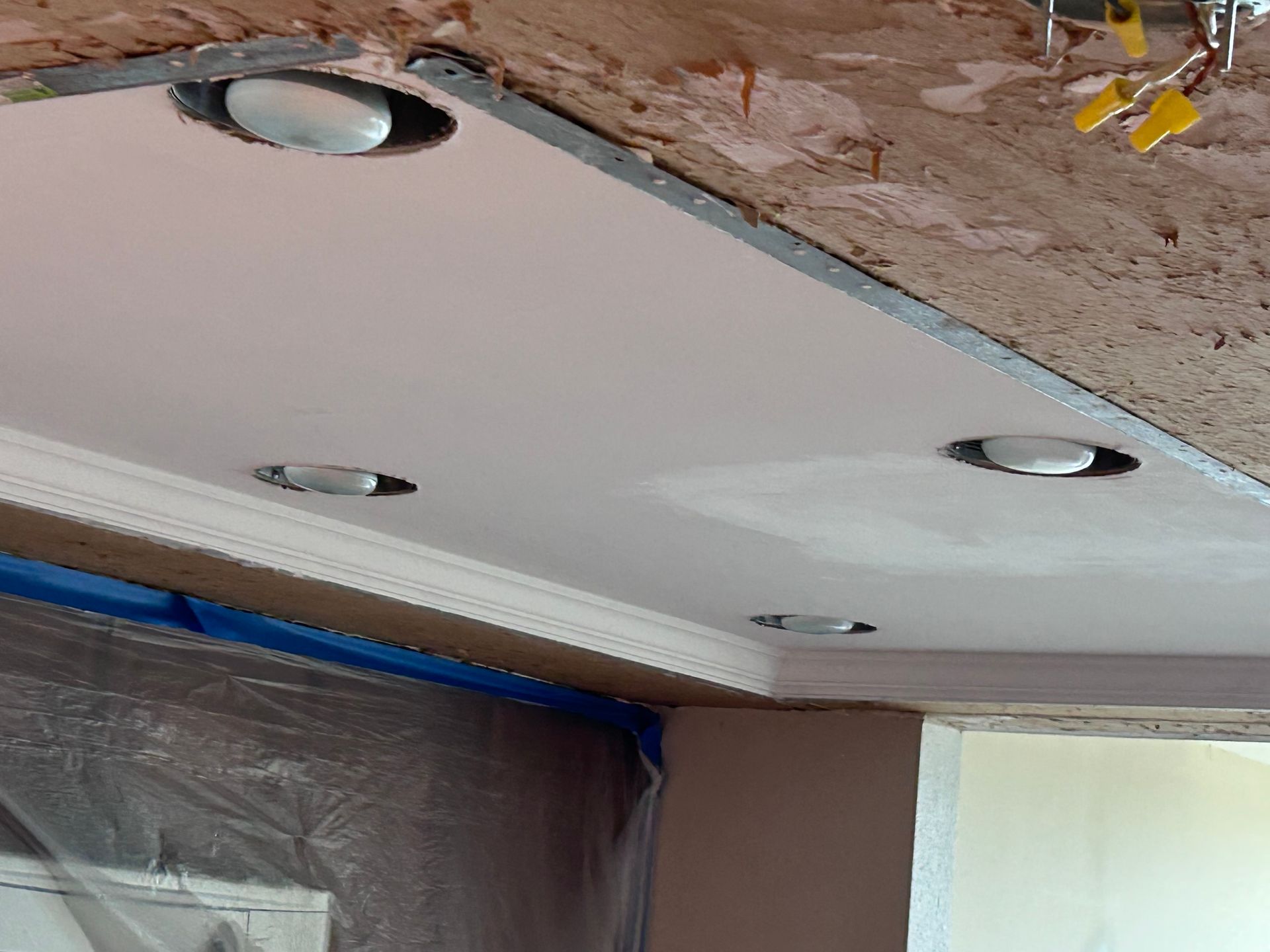 Close-up view of recessed ceiling lights installed in a newly constructed or renovated ceiling.