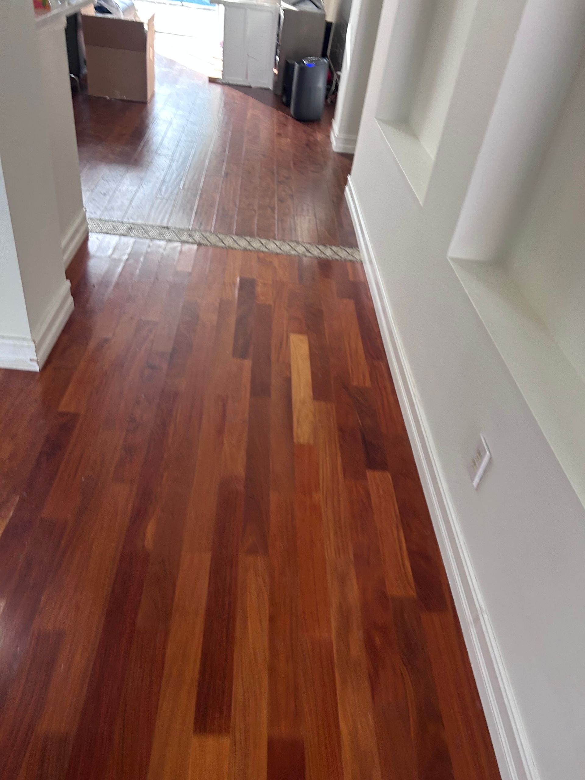 Wooden hallway with hardwood floors and white trim.
