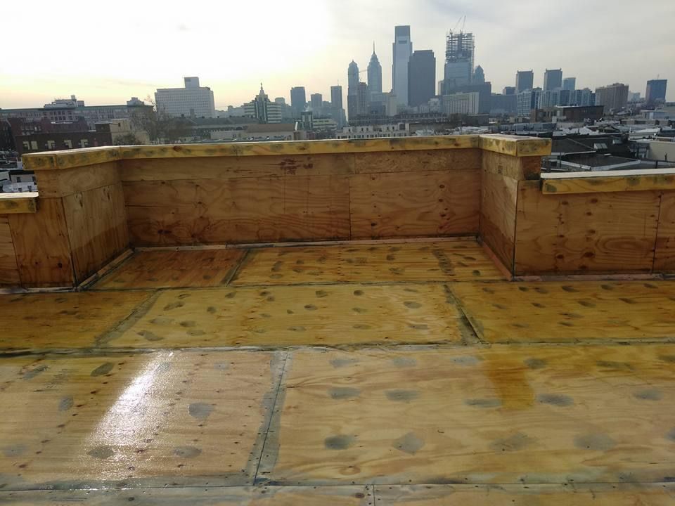 A rooftop with a city skyline in the background