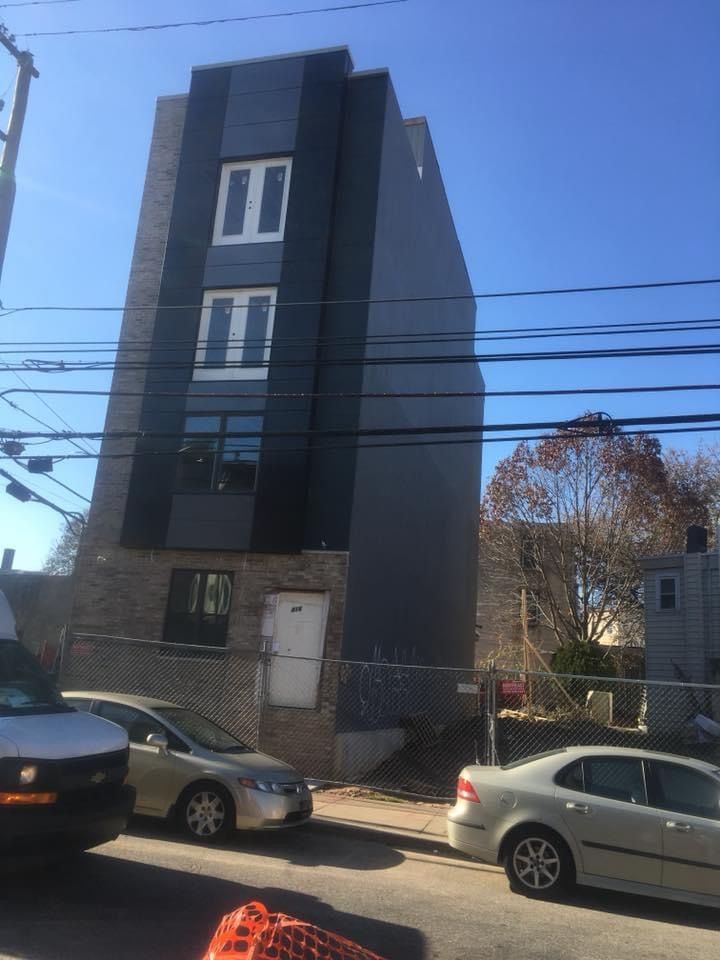 A tall building with a lot of windows and cars parked in front of it