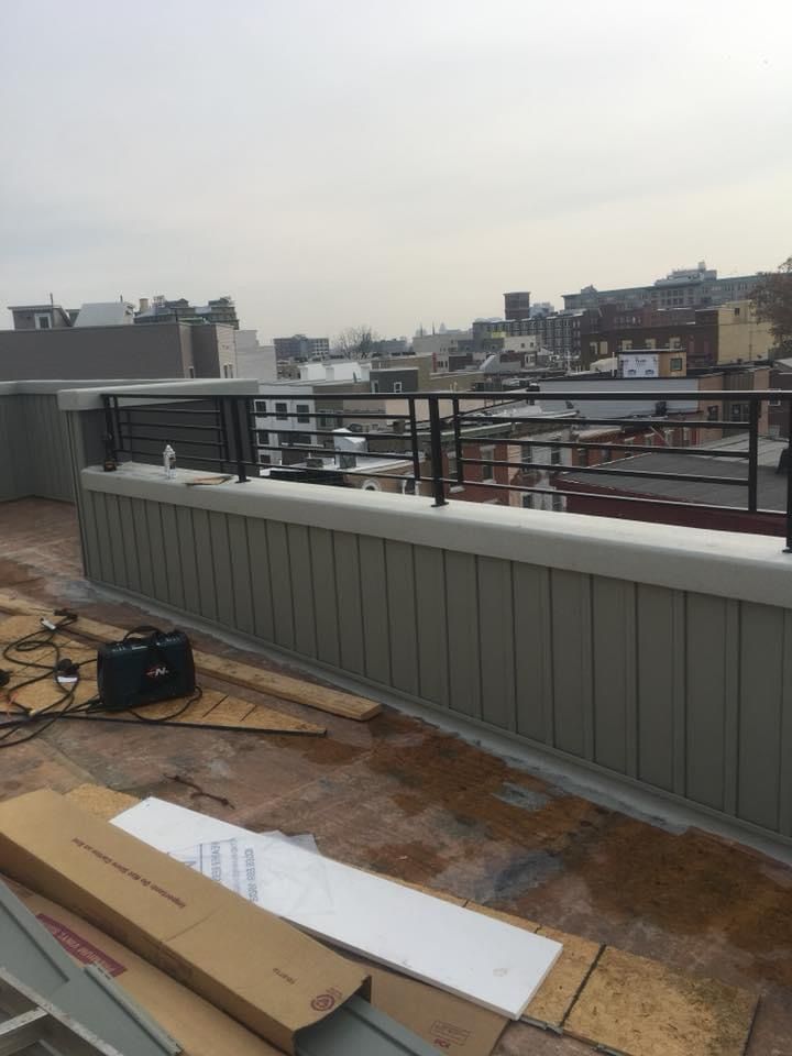 A rooftop with a railing and boxes on it