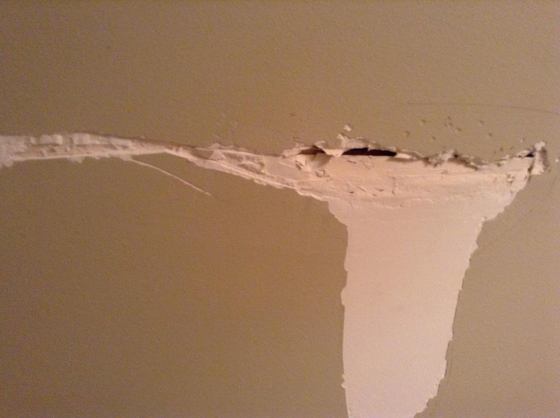 A hole in a wall that looks like a tornado