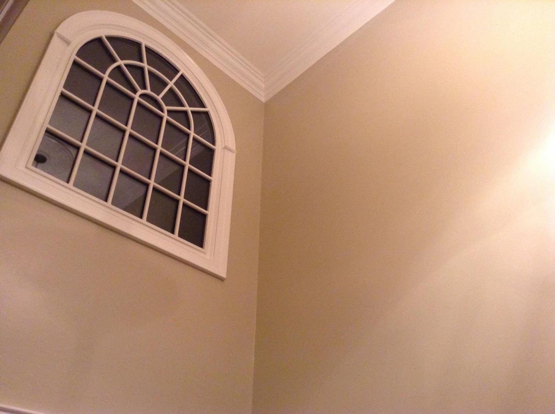 A window in the corner of a room with tan walls
