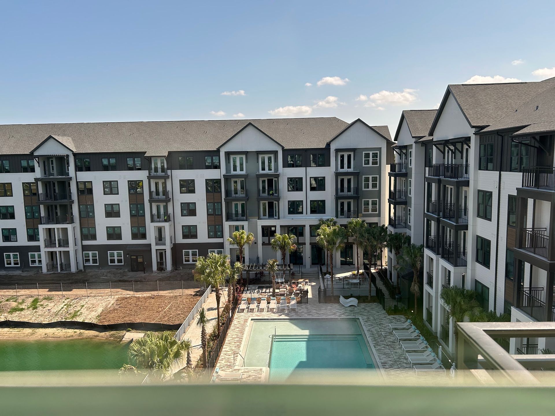 A large apartment building with a swimming pool in front of it.
