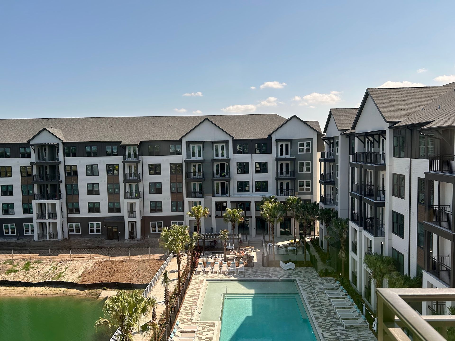 A large apartment building with a large swimming pool in front of it.