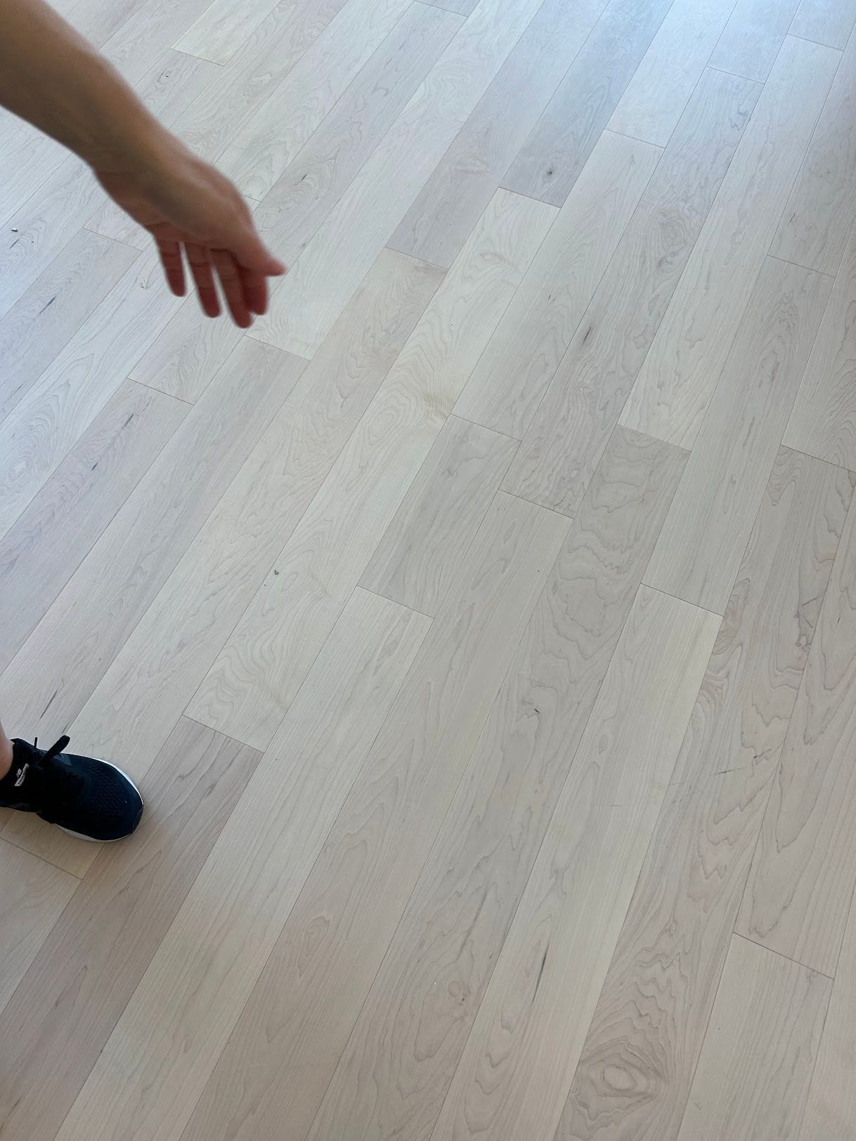 A person is standing on a white wooden floor.