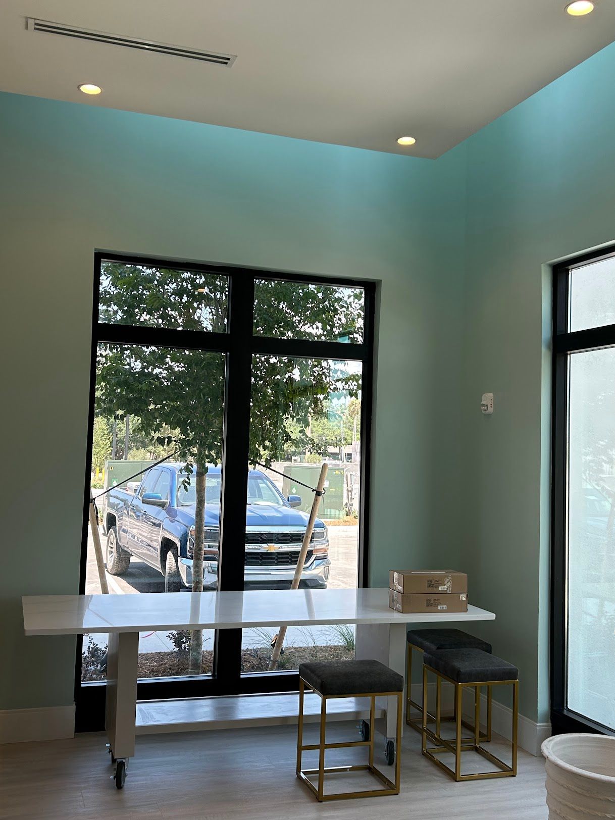 A room with a table and stools in front of a window