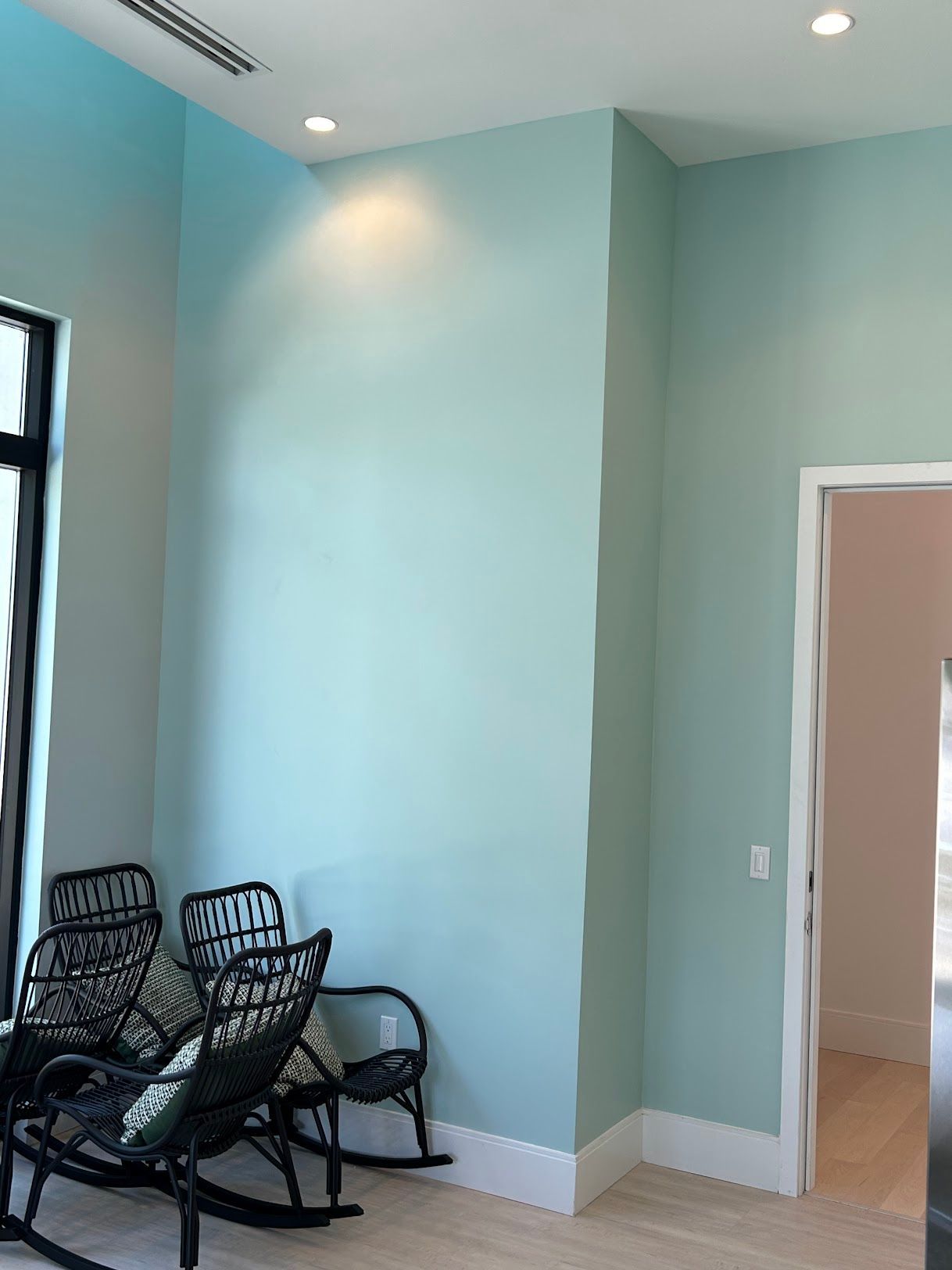 A living room with blue walls and rocking chairs