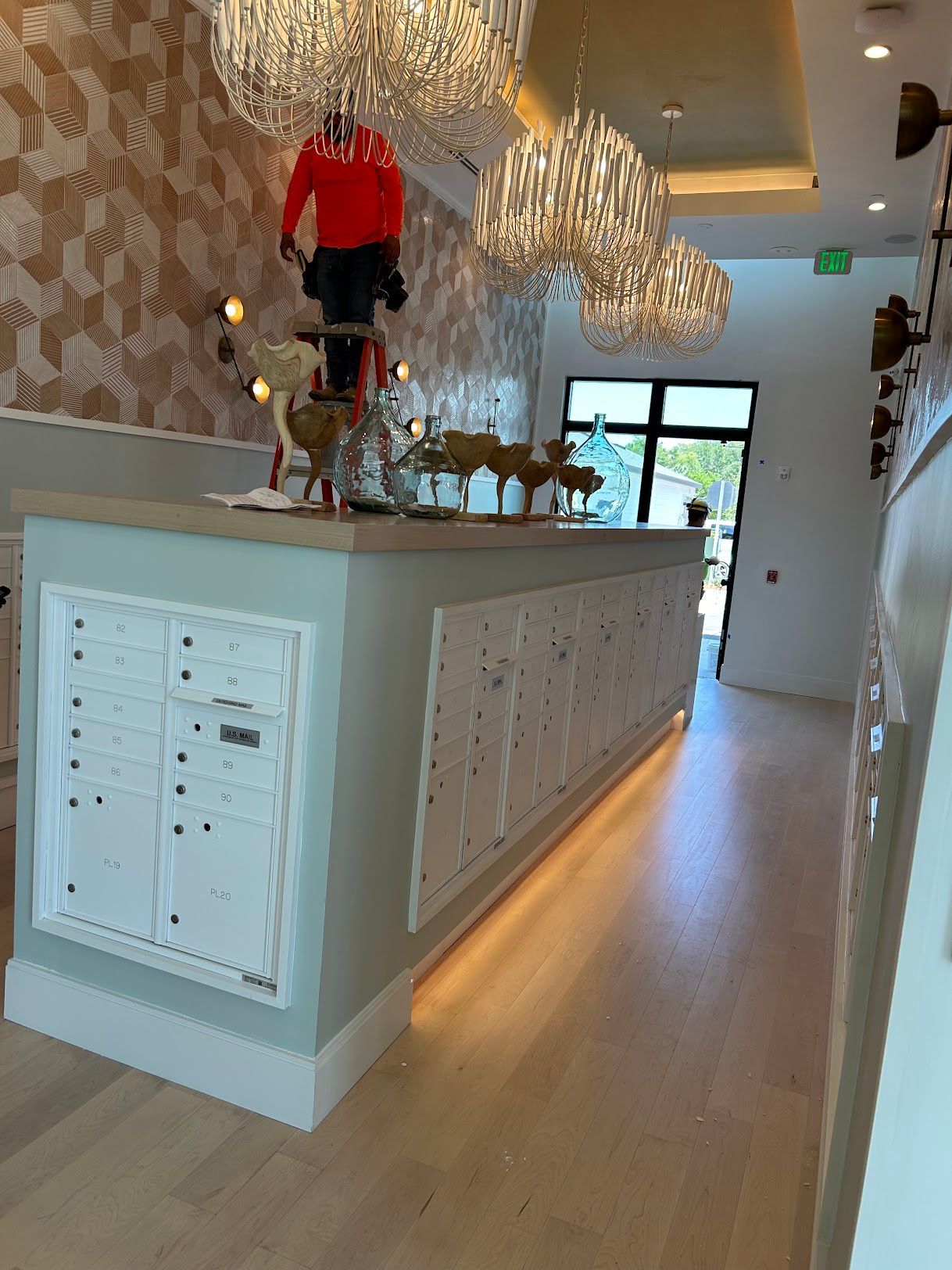 A long counter in a room with a lot of chandeliers hanging from the ceiling.