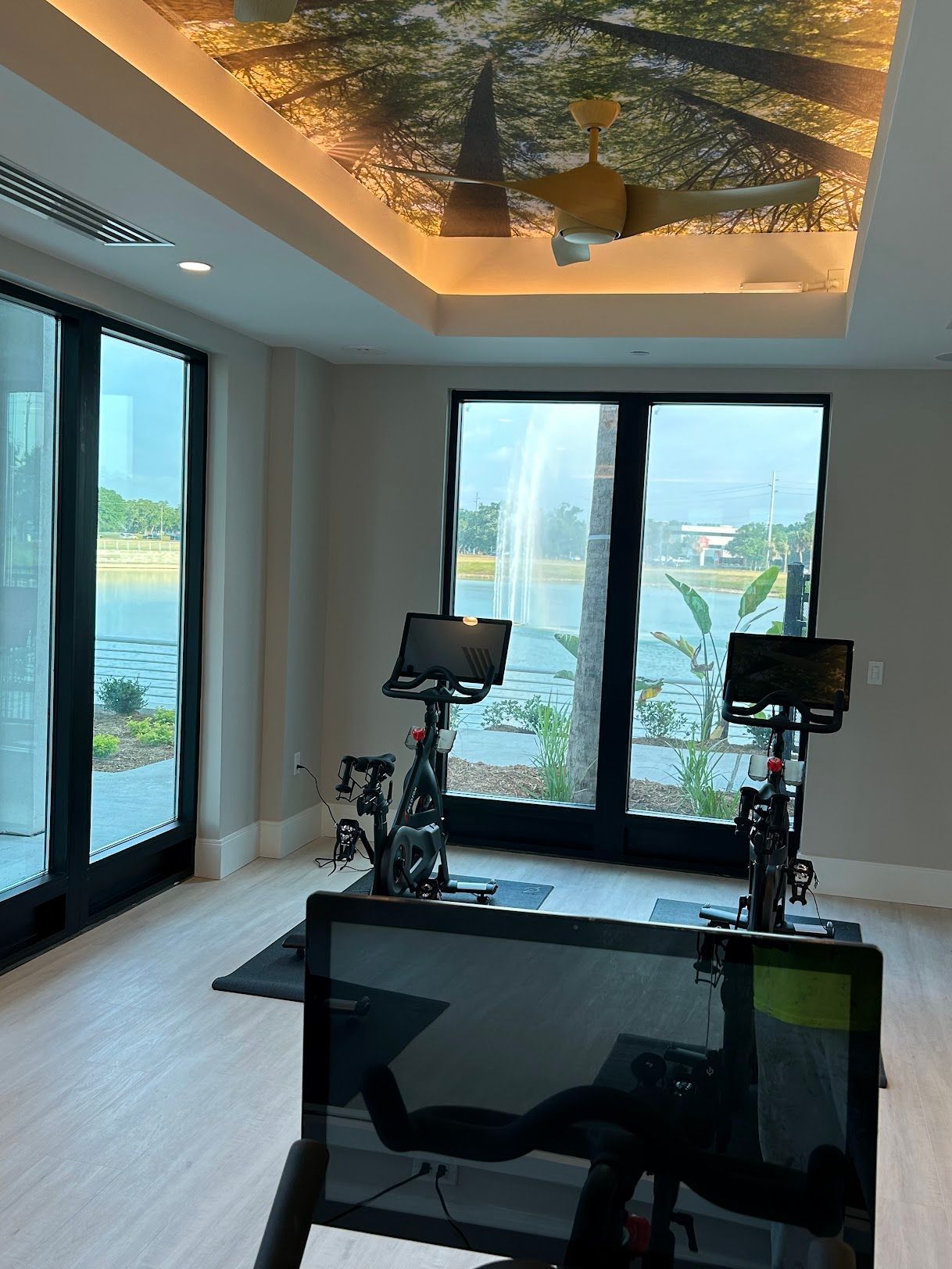 A room with two exercise bikes and a ceiling fan.