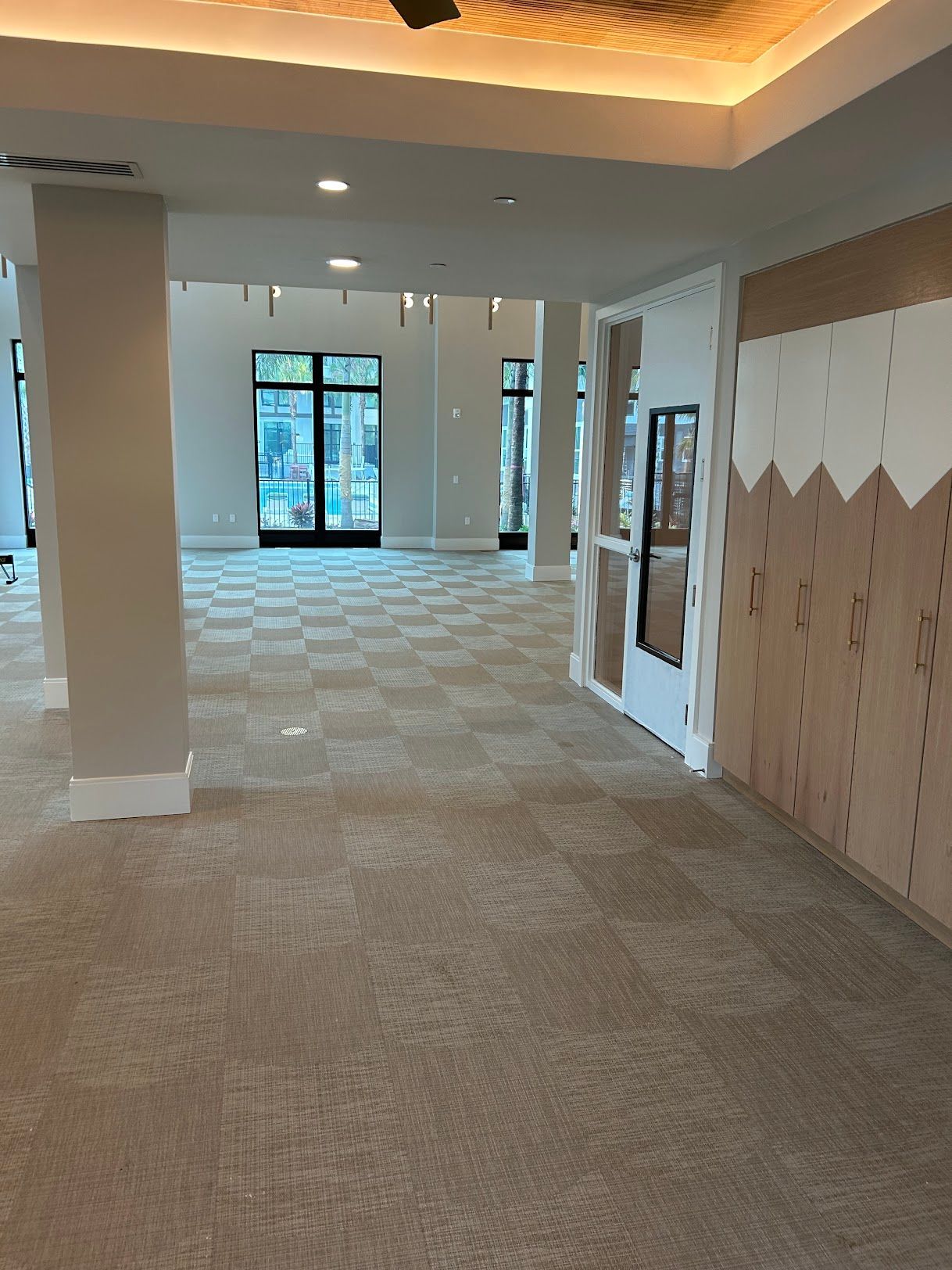 A large room with a lot of windows and a ceiling fan