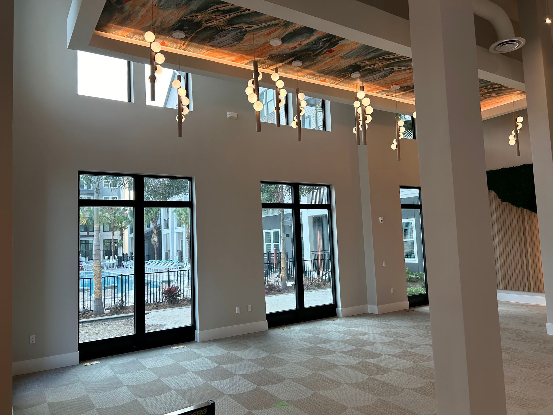 A large room with a lot of windows and a chandelier hanging from the ceiling