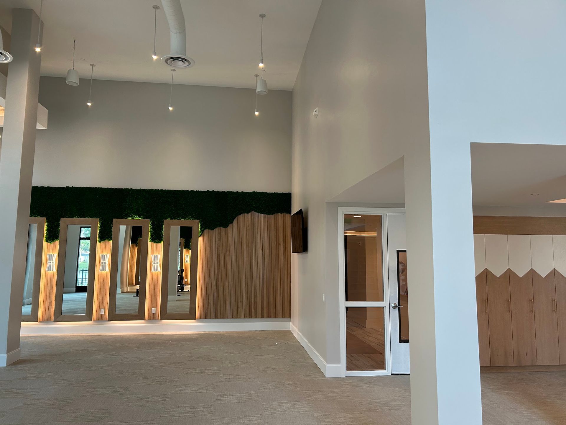 A large empty room with a wooden wall and a door