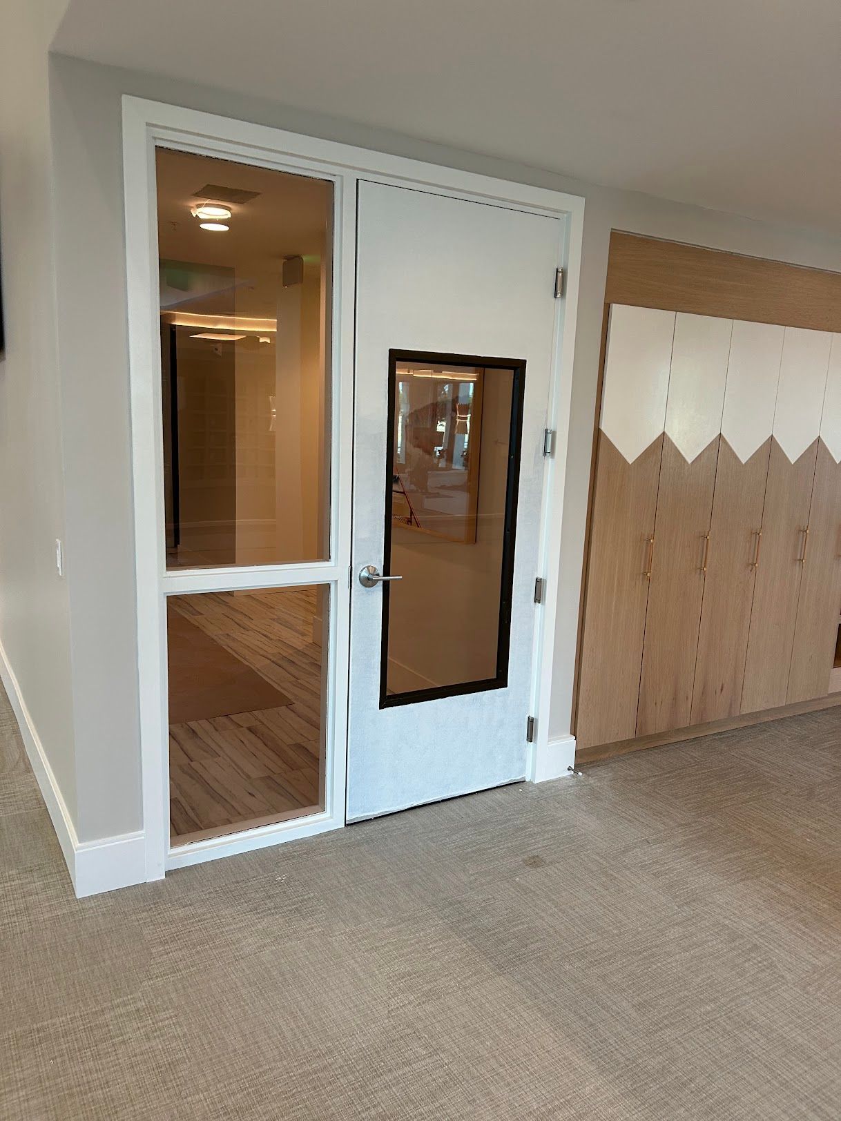 A white door with a glass window in a room.