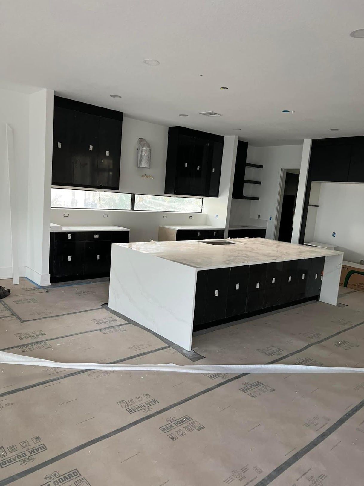 A kitchen under construction with a large island in the middle.