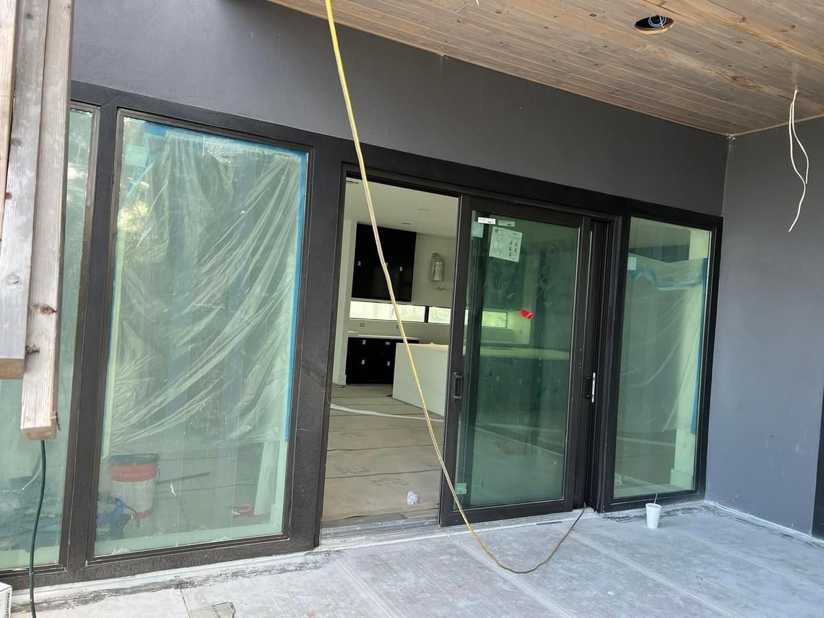 A building under construction with a lot of windows and sliding glass doors.