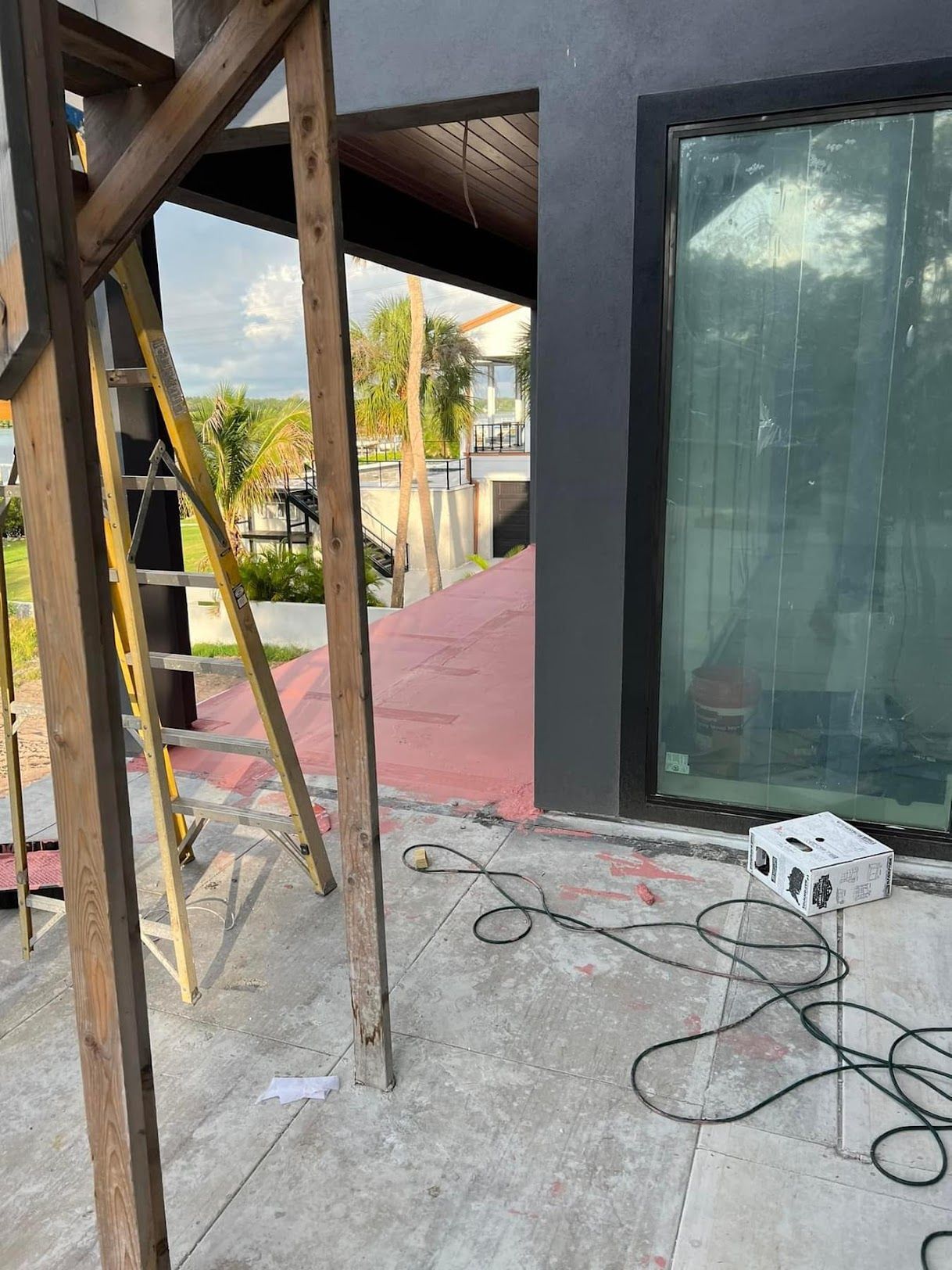 A projector is sitting on the ground in front of a building under construction.