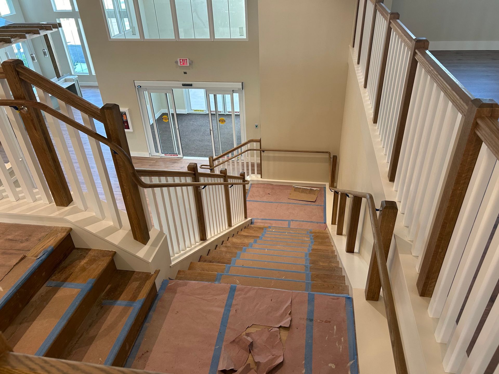 A staircase with a wooden railing is being built in a building.