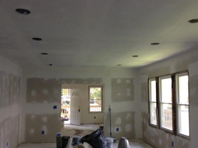 A room with a lot of windows and drywall on the walls