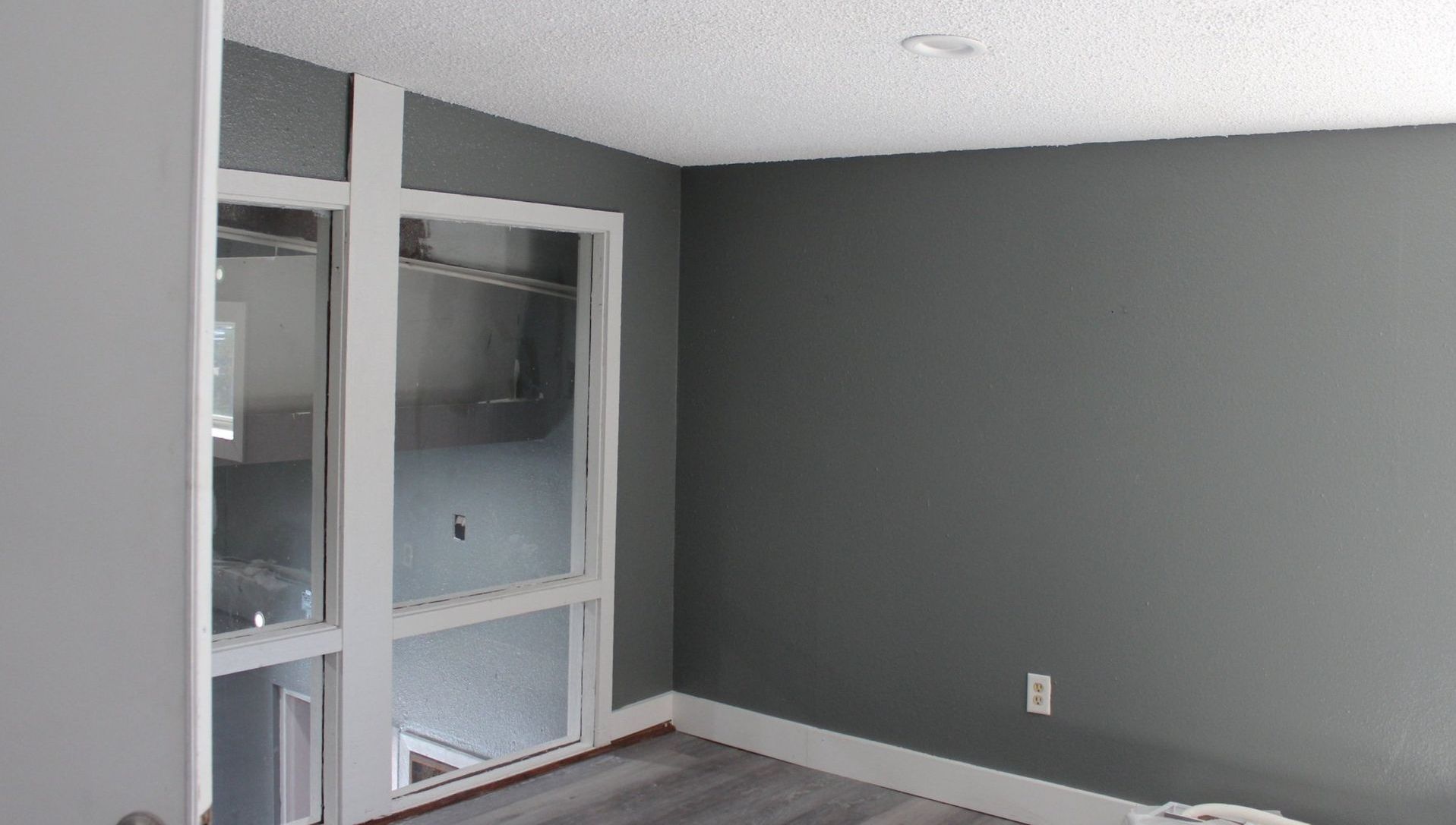 An empty room with gray walls and a window.