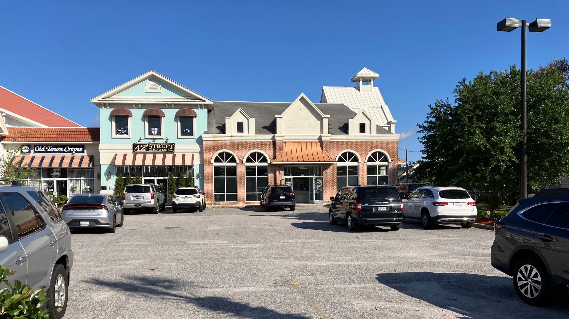 Street view of the shopping center. Church entrance is hidden from view on the north (right) side.
