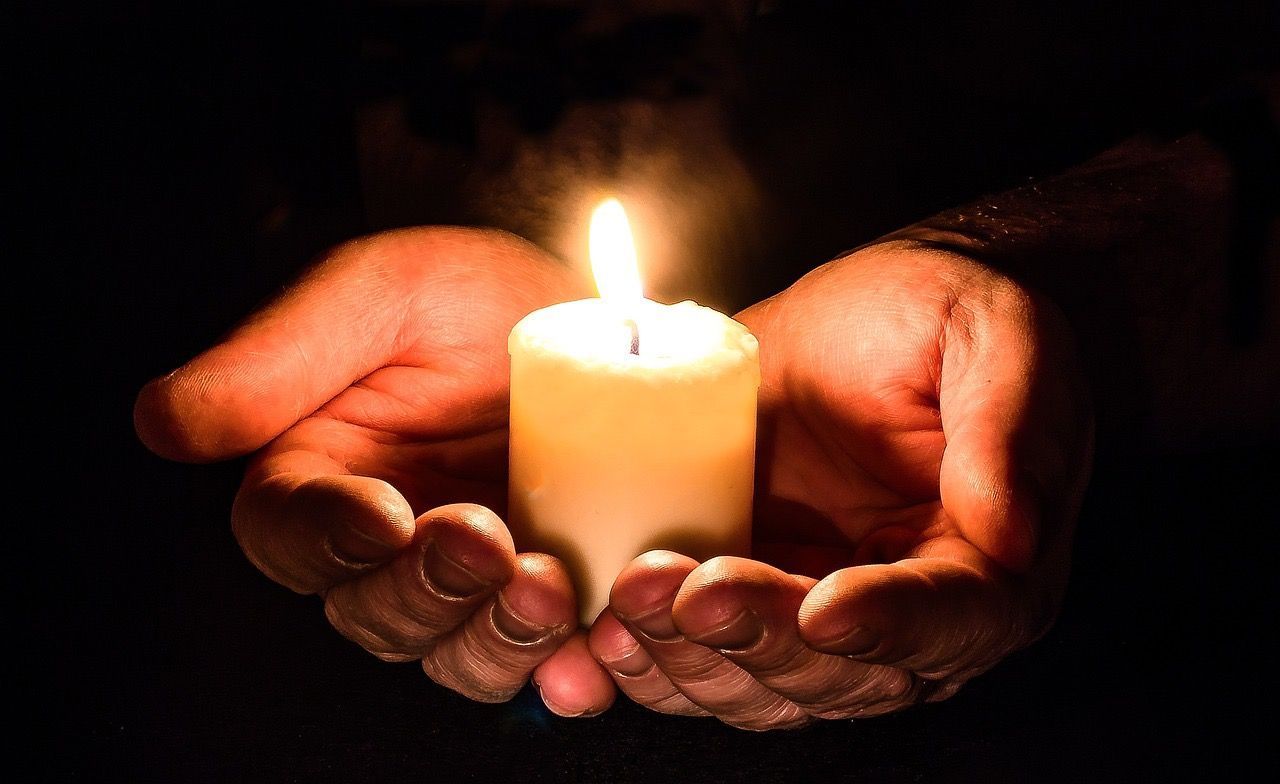 Praying hands with candle