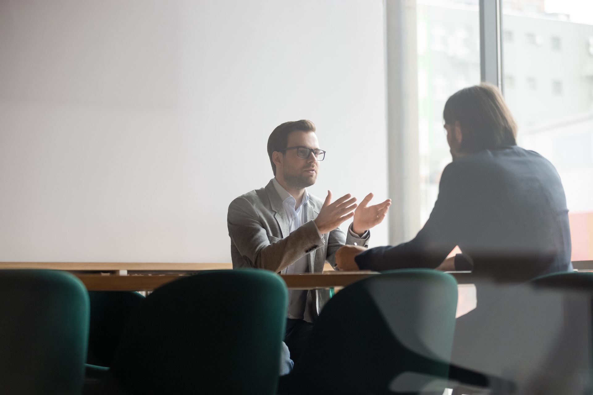 Two men are sitting at a table having a conversation.