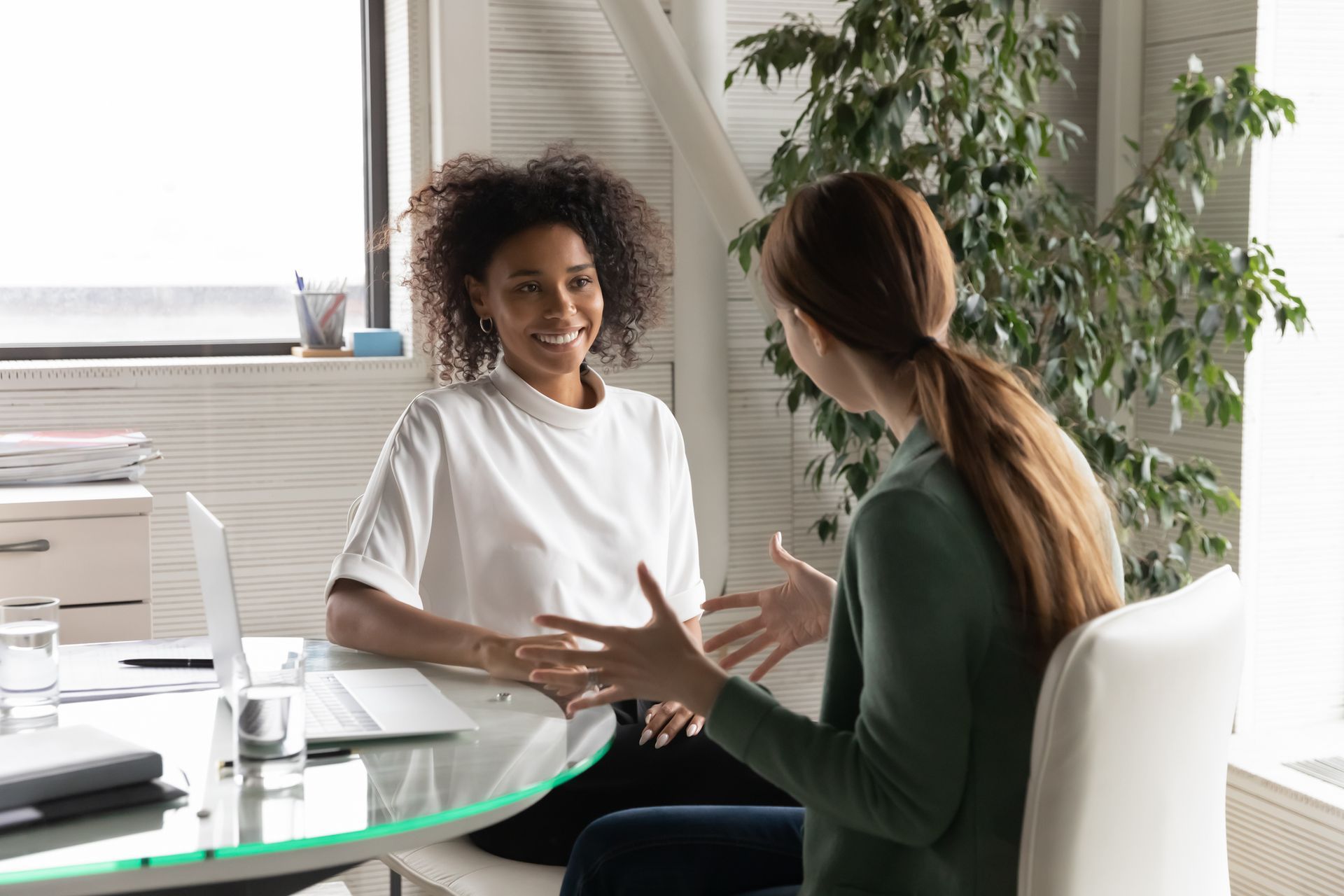 Two women are sitting at a table having a conversation.