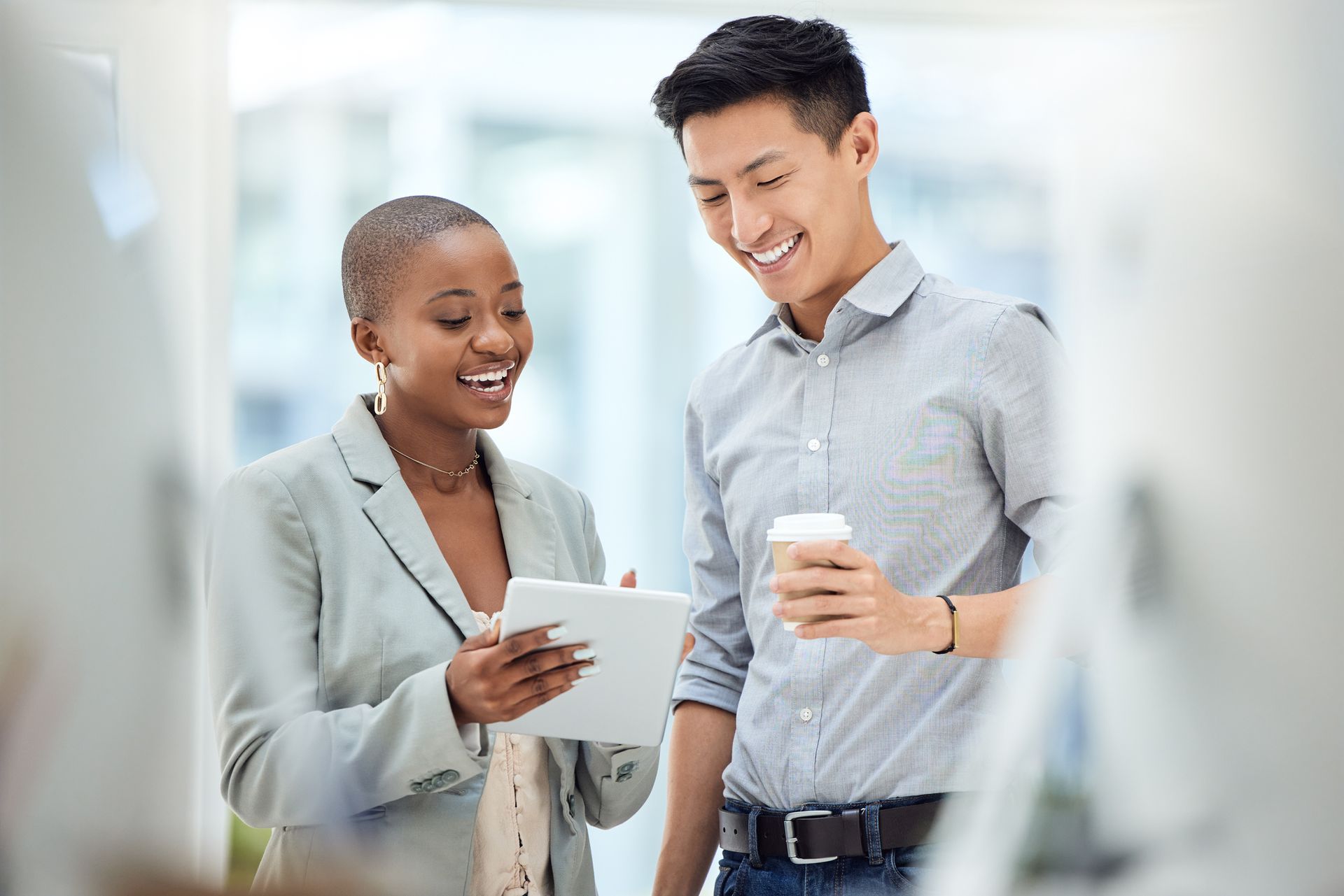 A man and a woman are looking at a tablet together.