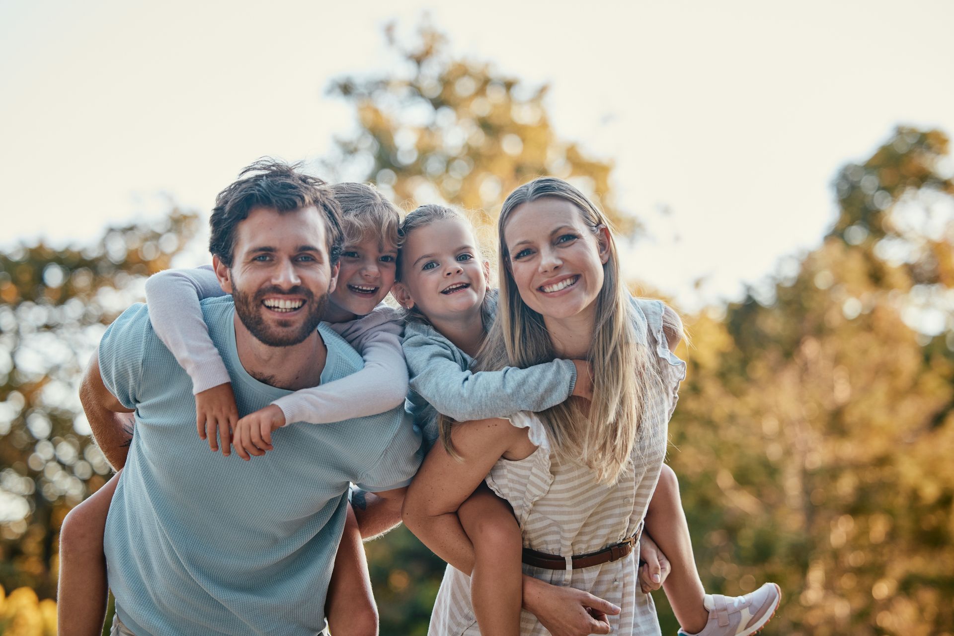 A family is posing for a picture together in a park.