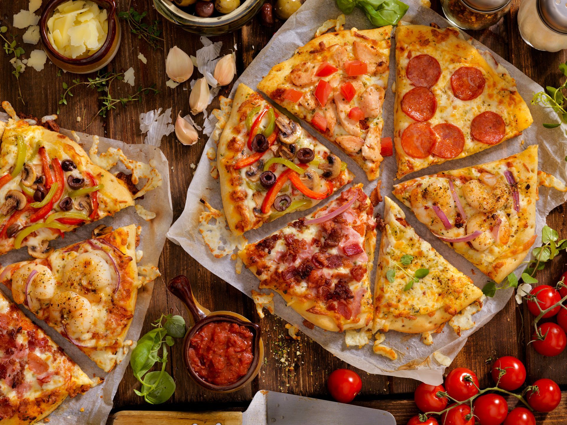 There are many different types of pizzas on the table.