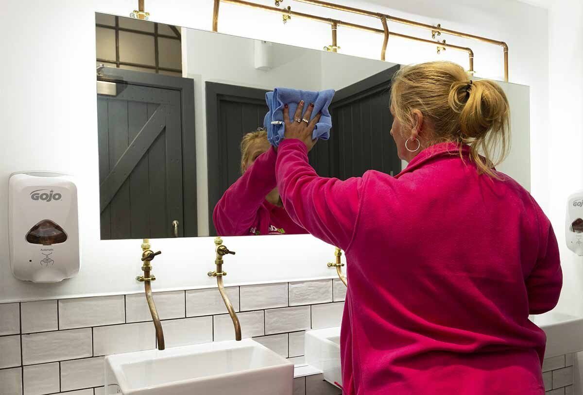 Cleaning mirror in office toilets