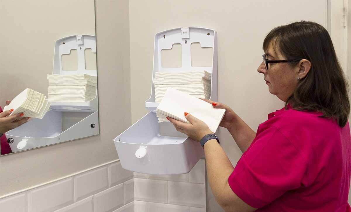 Filling paper towel dispenser in office washroom