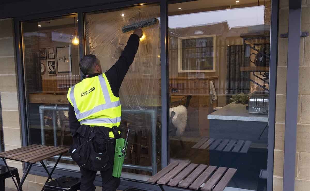 Window cleaner cleaning office cafeteria windows